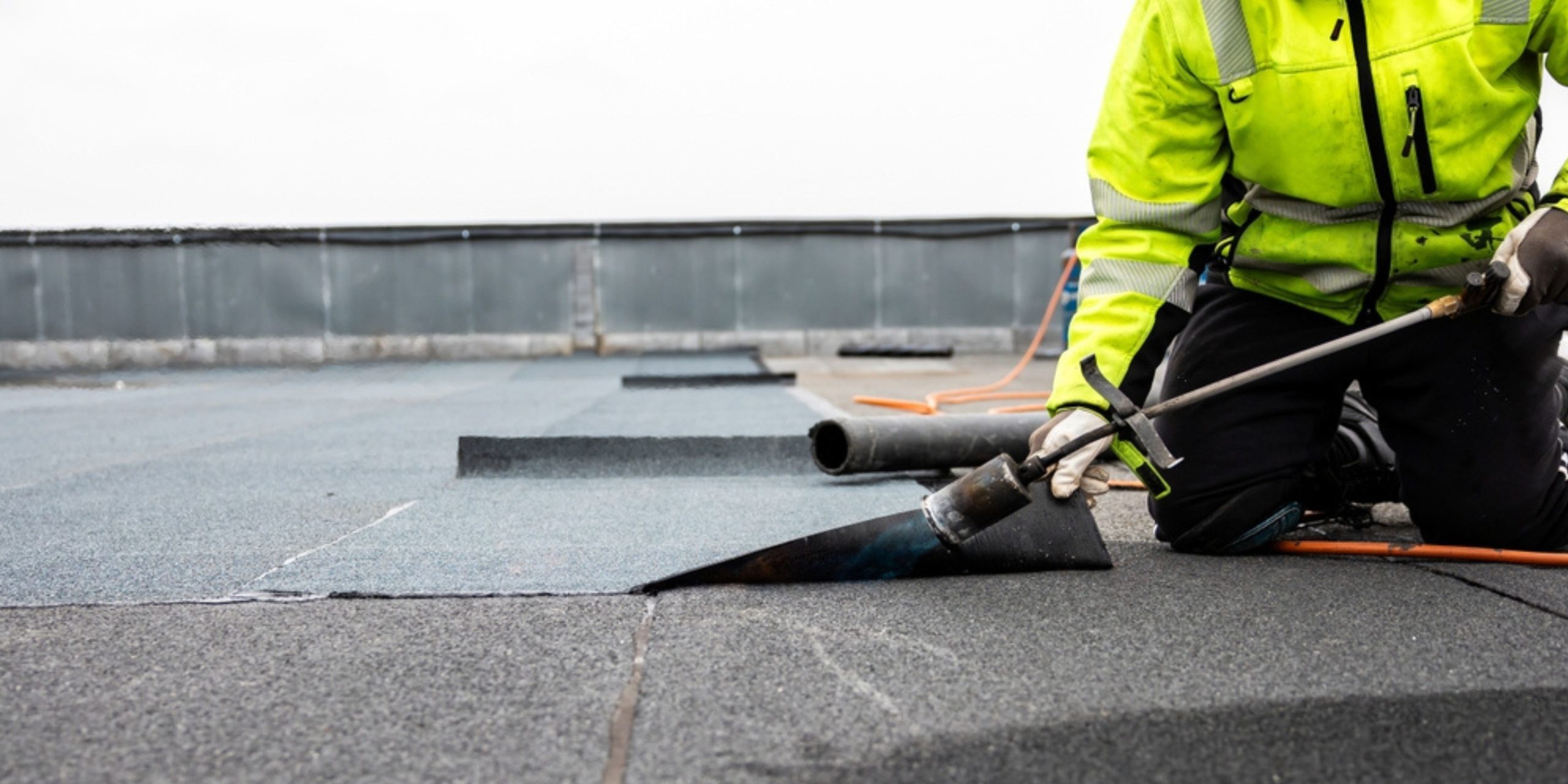 Flat roof installation process with tools and materials