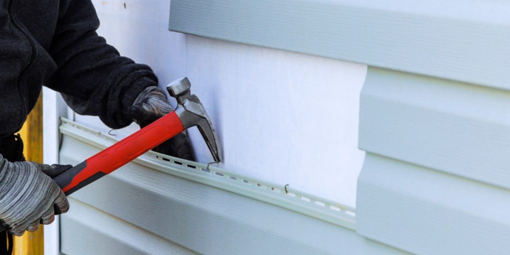 Professional siding contractors working on home exterior.